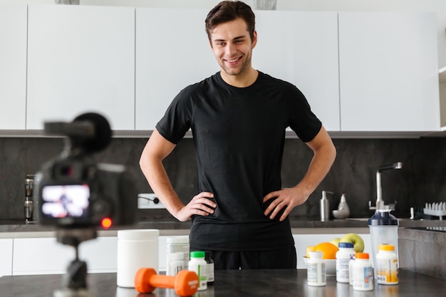 Free photo happy young man filming his video blog episode