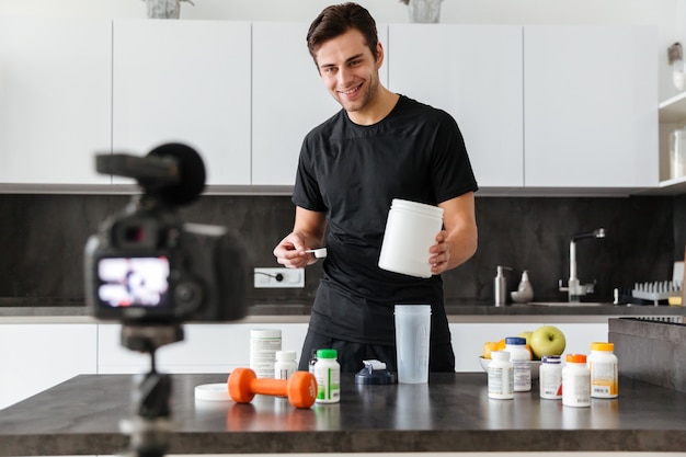 Happy young man filming his video blog episode