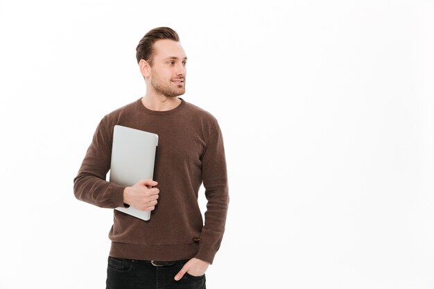 Happy young man holding laptop.