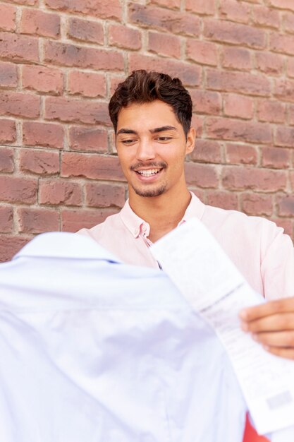 Happy young man looking at his shirt