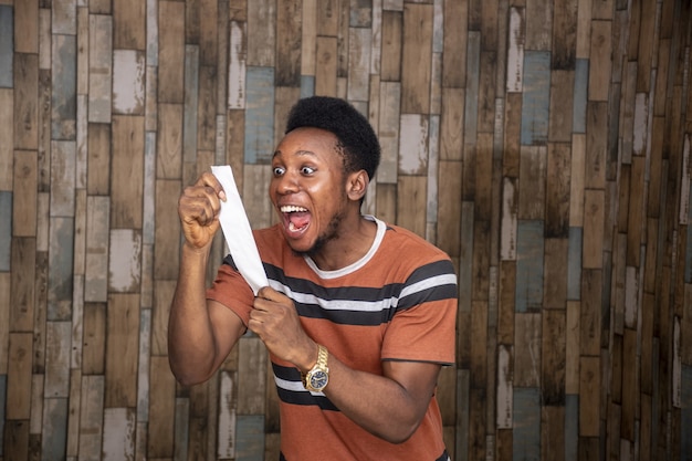 Happy young man looking at a piece of paper