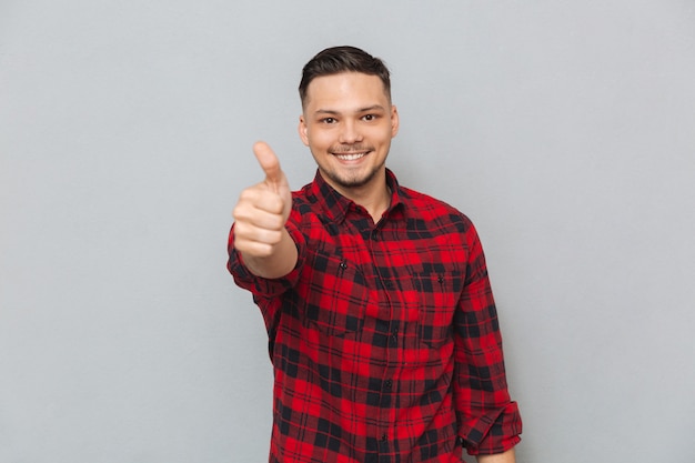 Happy young man make thumbs up gesture.