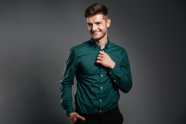 Happy young man posing isolated over grey 