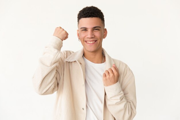 Happy young man shaking fists