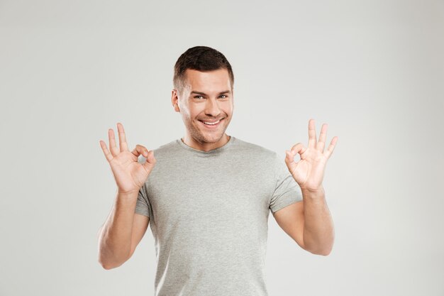 Happy young man showing okay gesture.