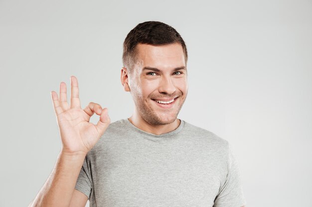 Happy young man showing okay gesture.