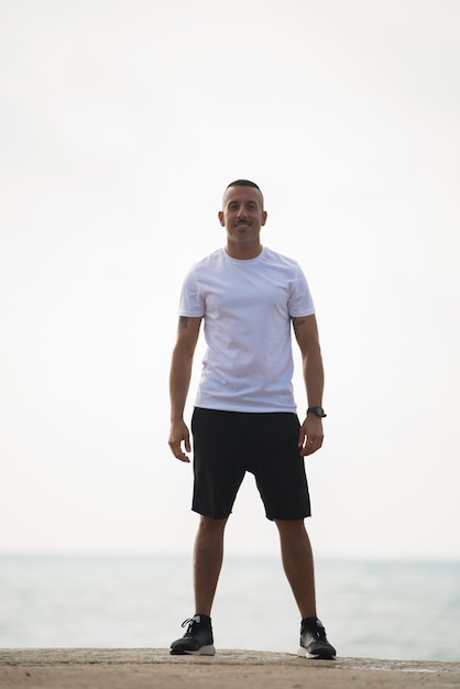 Happy young man in sport clothing smiling at camera