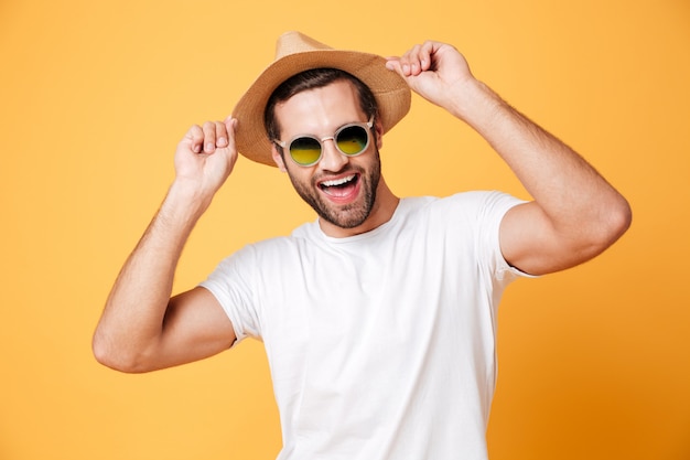 Happy young man standing isolated over orange wall