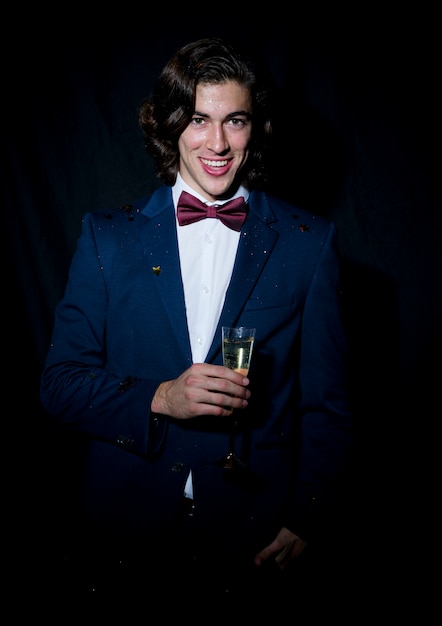 Free photo happy young man standing with champagne glass