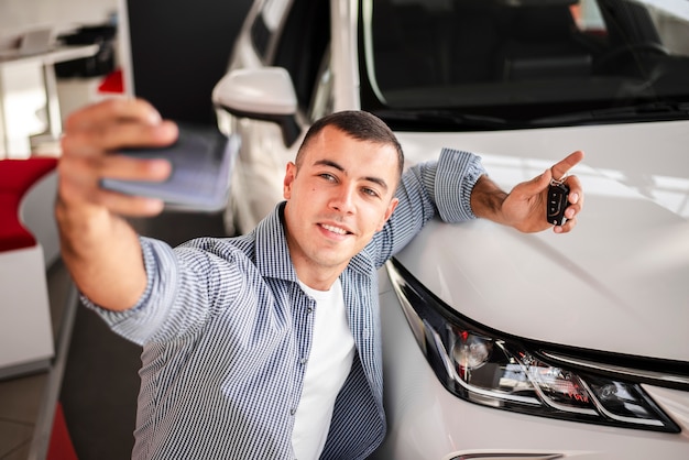 Happy young man taking a picture with the car