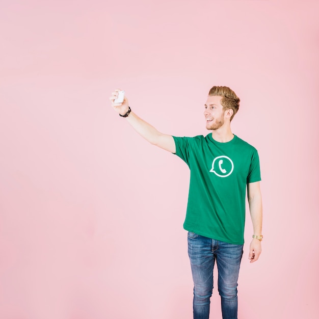 Happy young man taking selfie with smartphone