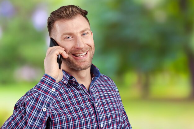 携帯電話で話している幸せな若い男