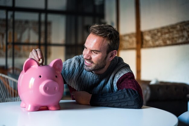 Happy young man with saving piggy bank