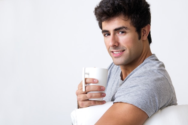 Free photo happy young man with a steamy cup of coffee at home