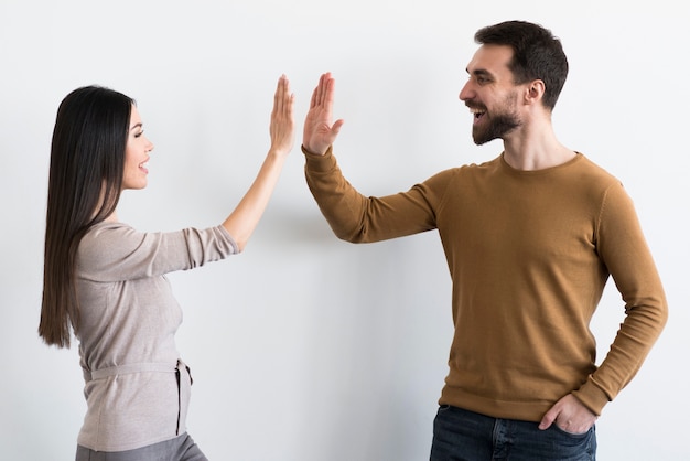 Happy young man and woman high five together