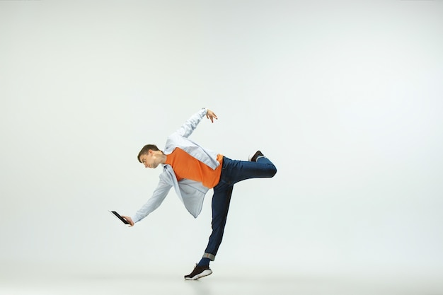 Happy young man working at office, jumping and dancing in casual clothes or suit isolated on white  background.