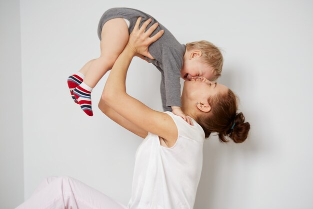 Happy young mother with little son at home