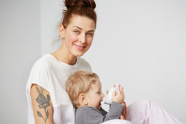 Happy young mother with little son at home