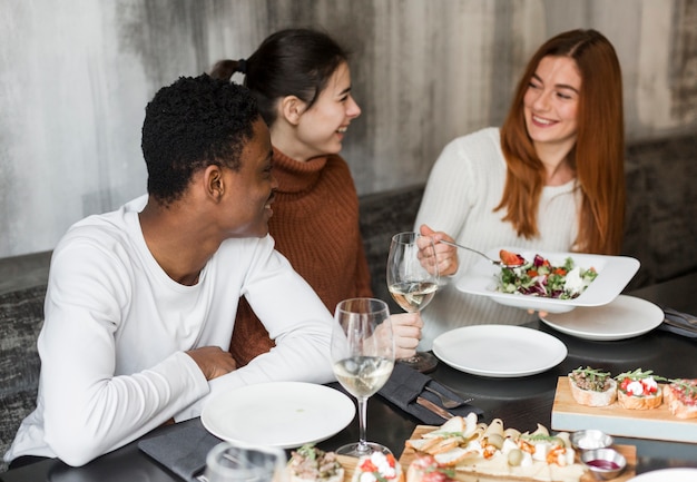 Giovani felici che godono insieme della cena