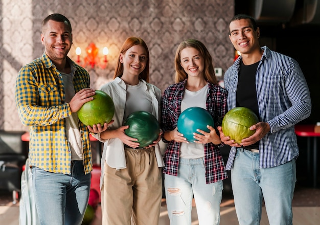 Giovani felici che stanno in un club di bowling