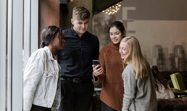 Happy young people watching a video on a mobile phone