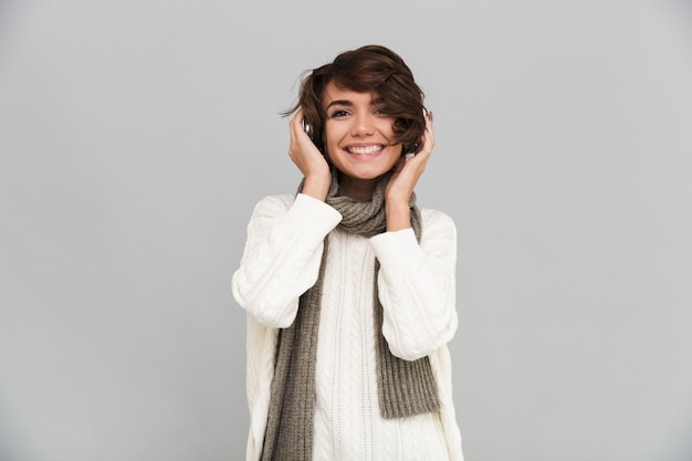 Happy young pretty woman wearing scarf standing isolated