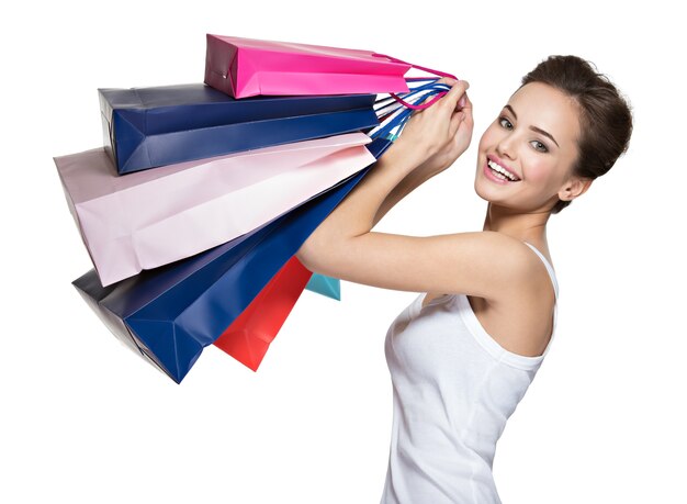 Счастливая молодая улыбающаяся женщина с хозяйственными сумками после покупок