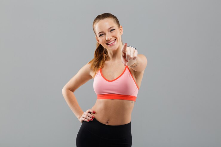 Free Photo happy young sports woman pointing to you.