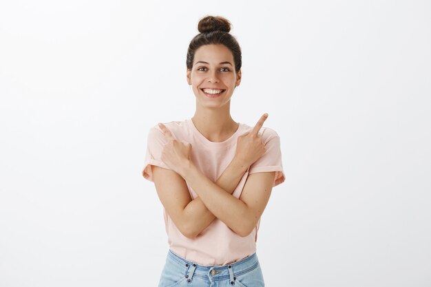 Happy young stylish woman posing against the white wall