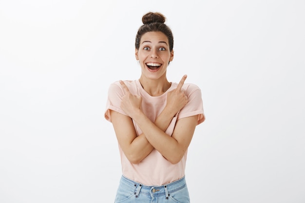 Happy young stylish woman posing against the white wall