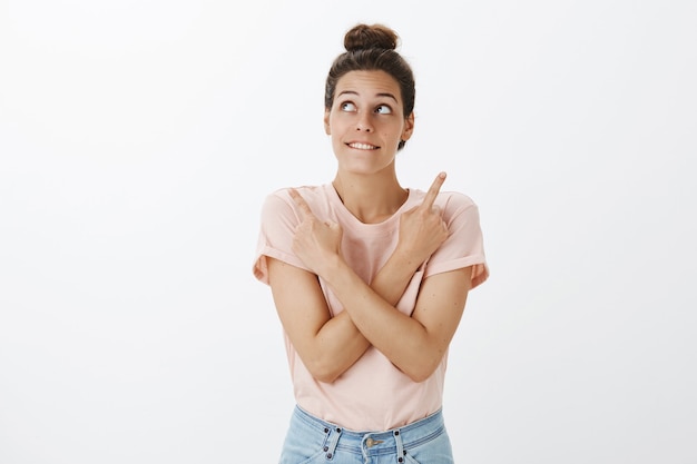 Foto gratuita felice giovane donna alla moda in posa contro il muro bianco