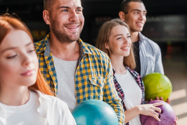 Foto gratuita felice giovane squadra che tiene le palle da bowling