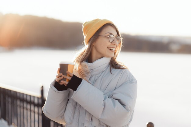 테이크 아웃 커피 컵을 들고 행복 한 젊은 십 대 여자