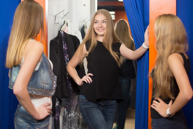 Happy young woman choosing her new clothes