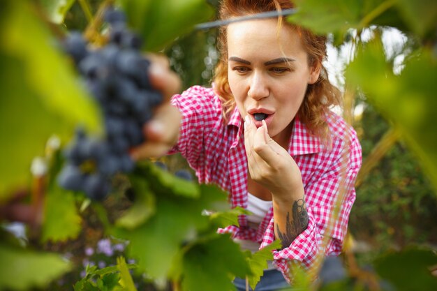 庭でベリーを食べる幸せな若い女性