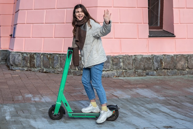 Happy young woman on electric scooter in the city