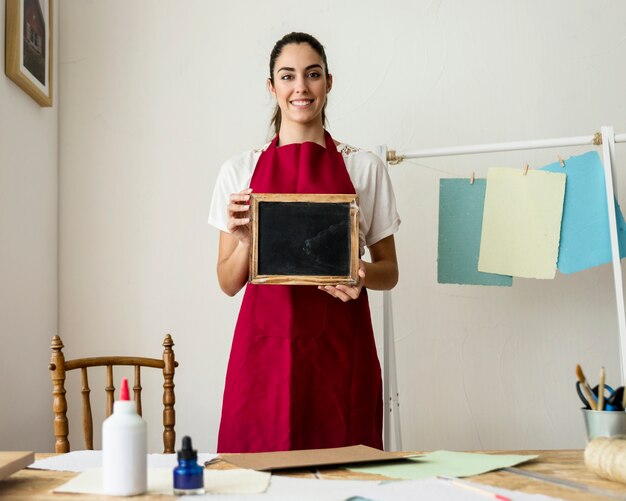 Happy young woman holding deckle with black paper