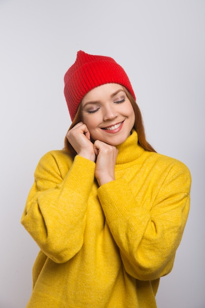 Бесплатное фото Счастливая молодая женщина в красной вязаной шапке