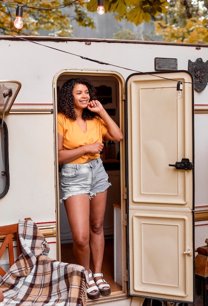 Foto gratuita felice giovane donna appoggiata a una porta