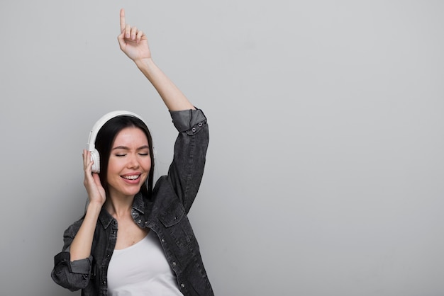 Free photo happy young woman listening to music