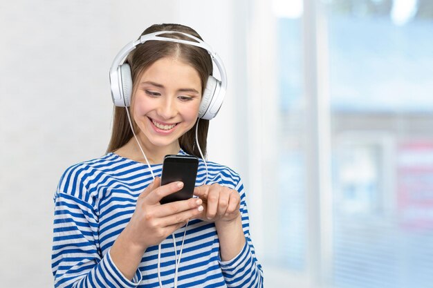 Счастливая молодая женщина, слушающая музыку