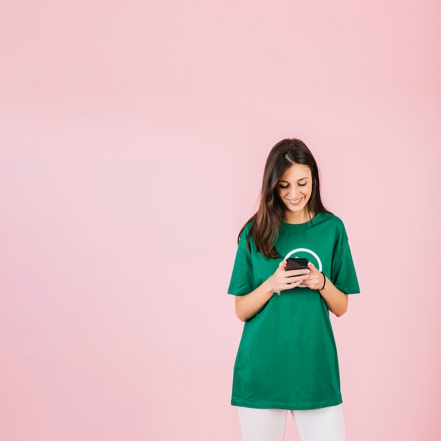 Happy young woman looking at mobile phone