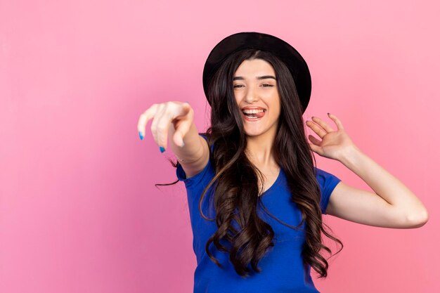 Happy young woman pointing her finger to the camera and laughing