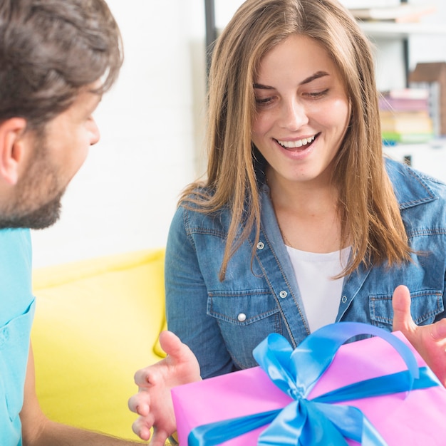 Happy young woman receiving gift from her husband