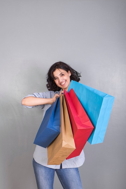 Free photo happy young woman in shirt with shopping bags