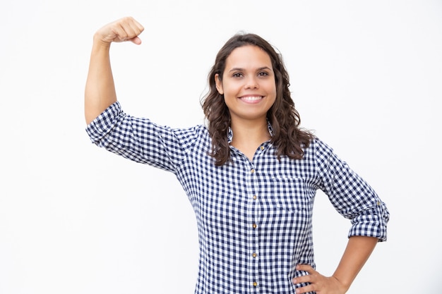 Happy young woman showing biceps