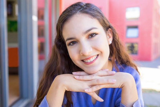 Happy young woman smiling at camera outdoors