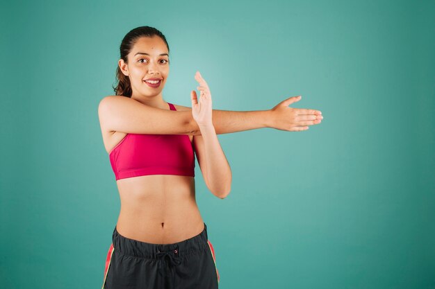 Free photo happy young woman stretching arms before training