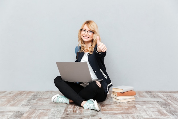 Happy young woman student using laptop computer.