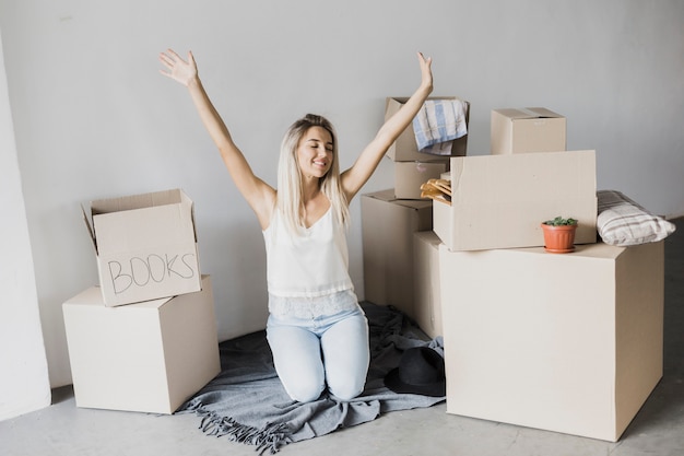 Free photo happy young woman surrounded by boxes